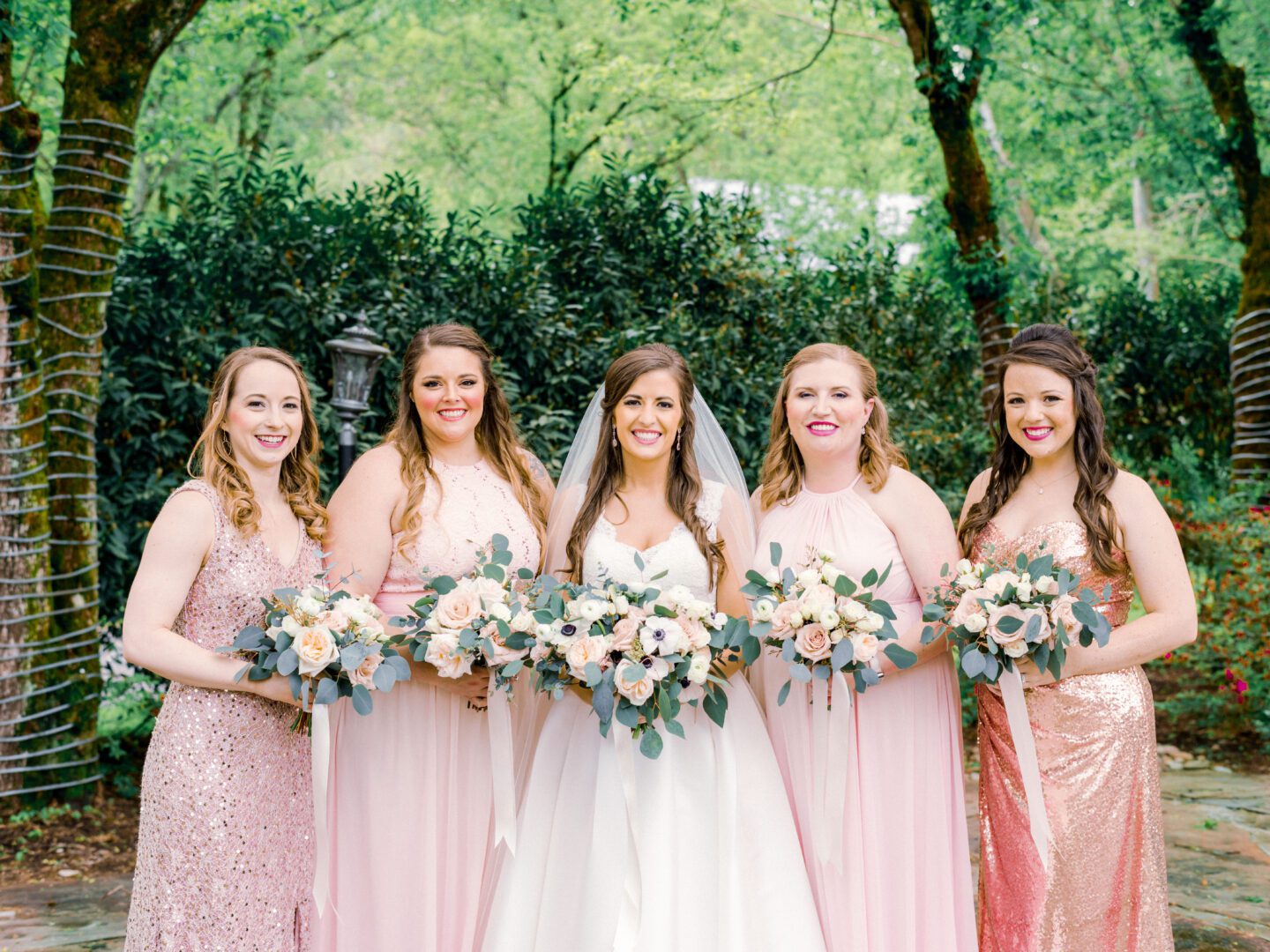A group of bridesmaids in pink dresses pose for a photo.